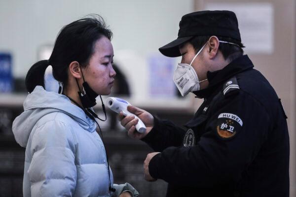 Security personnel check the temperature of passengers in the Wharf at the Yangtze River in Wuhan, Hubei province, China, on Jan. 22, 2020. (Getty Images)