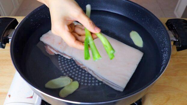Boiling the pork belly with aromatics. (CiCi Li)