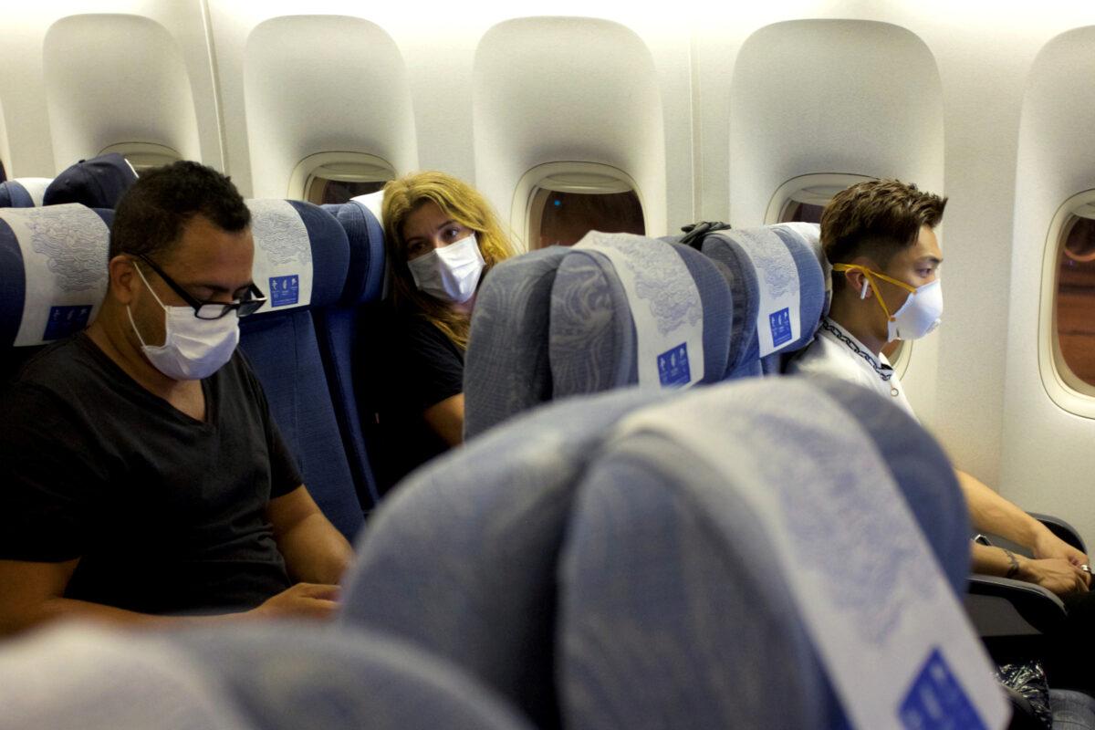 Passengers wearing masks sit on an Air China flight from Sydney to Beijing before takeoff, in Sydney, Australia on Jan. 24, 2020. (Thomas Peter/Reuters)