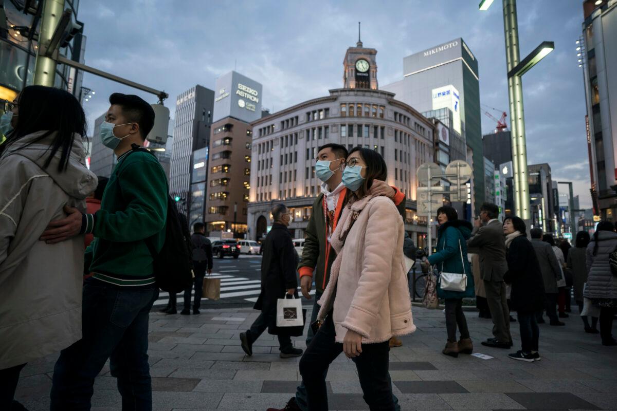 Chinese tourists wearing masks walk through the Ginza shopping district in Tokyo, Japan on Jan. 24, 2020. (Tomohiro Ohsumi/Getty Images)