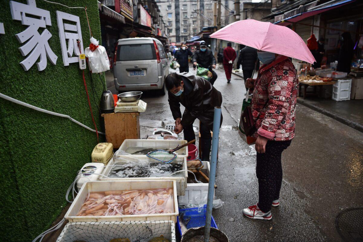 A masked vendor sells fish and turtles at a market in Wuhan, where the coronavirus was discovered, in China on Jan. 24, 2020. (Hector Retamal/AFP via Getty Images)