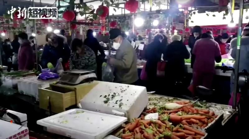 People wearing masks shop at a market in Wuhan, Hubei province, China on Jan. 23, 2020, in this still image taken from video. (China News Service/via Reuters TV)