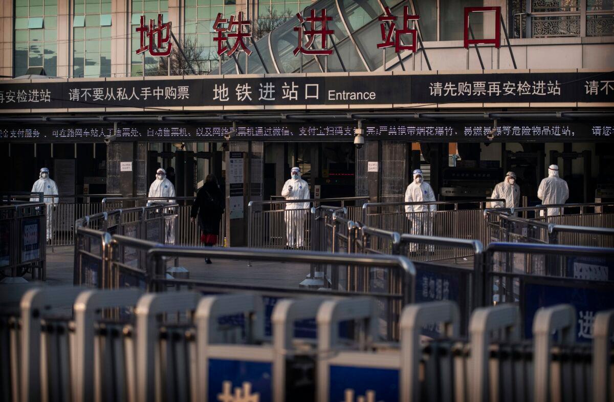 Chinese health workers wait to check the temperature of travelers entering a subway station in Beijing on Jan. 25, 2020. (Kevin Frayer/Getty Images)