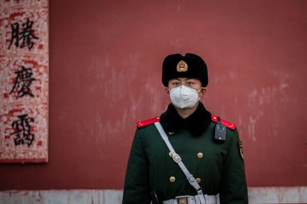 A paramilitary police officer wearing a protective facemask to help stop the spread of a deadly SARS-like virus, which originated in the central city of Wuhan, stands guard at the exit of the Forbidden City in Beijing, China, on Jan. 25, 2020. (Nicolas Asfouri/AFP via Getty Images)