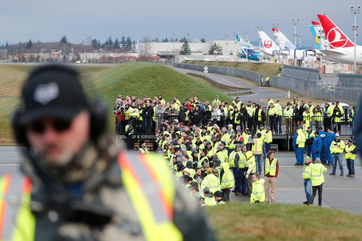 Boeing employees, clients, and others watch as a Boeing 777X airplane taxis during its first test flight from the company's plant in Washington state, on Jan. 25, 2020. (Terray Sylvester/Reuters)