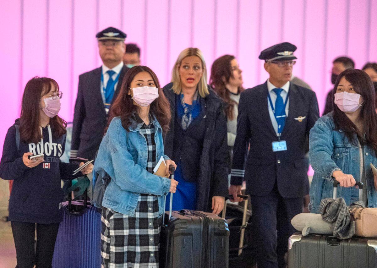 Passengers wear masks to protect against the spread of the Coronavirus as they arrive at the Los Angeles International Airport, Calif., on Jan. 22, 2020. (Mark Ralston/AFP via Getty Images)