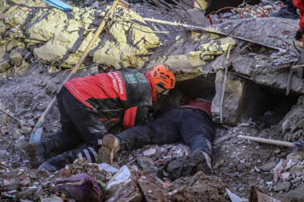 Rescue workers try to save people trapped under debris following a strong earthquake that destroyed several buildings on Friday, in Elazig, eastern Turkey, on Jan. 26, 2020. (Ismail Coskun/IHA via AP)