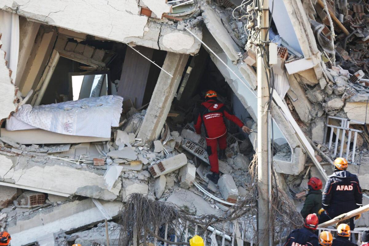 Rescuers work on searching for people buried under the rubble on a collapsed building, after an earthquake struck Elazig, eastern Turkey, on Jan. 25, 2020. (IHH/ Humanitarian Relief Foundation via AP)