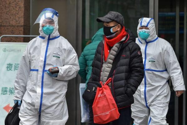 Medical staff wearing clothing to protect against a previously unknown virus walk outside a hospital in Wuhan on Jan. 26, 2020. (Hector Retamal/AFP via Getty Images)