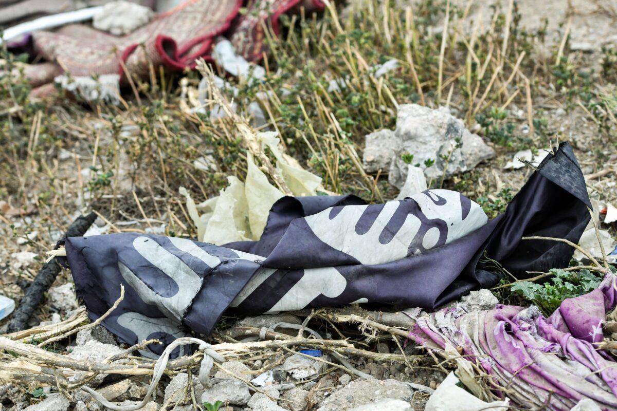This picture taken shows a discarded ISIS terrorist group flag lying on the ground in the village of Baghouz in Syria's eastern Deir Ezzor province near the Iraqi border, on March 24, 2019. (Giuseppe Cacace/AFP via Getty Images)