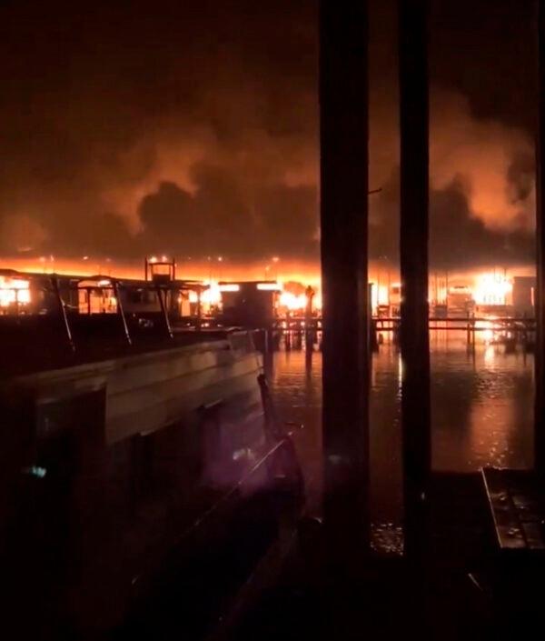 A fire burns on a dock where at least 35 vessels, many of them houseboats, were destroyed by fire early on Jan. 27, 2020, in Scottsboro, Ala. (DeWayne Patterson/Jackson County Sentinel via AP)
