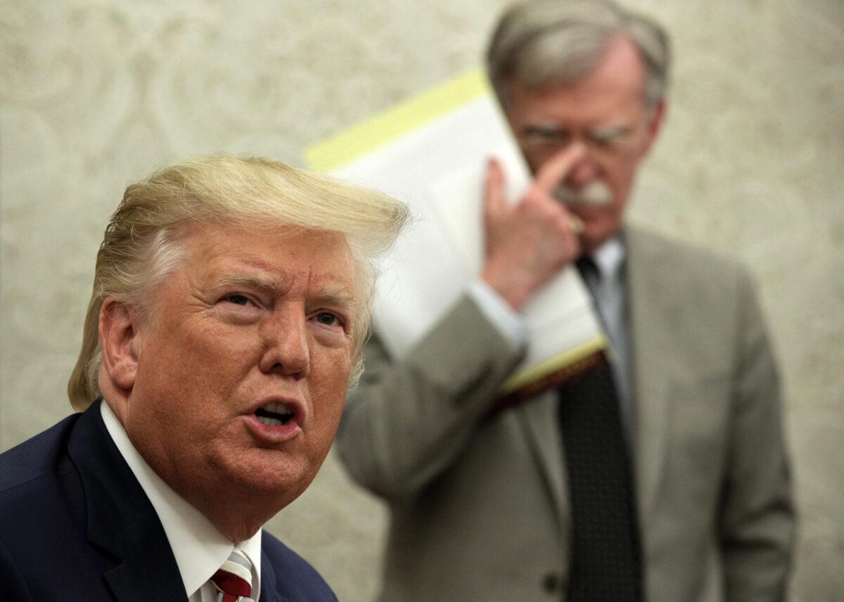 President Donald Trump speaks to members of the media as National Security Adviser John Bolton listens in the Oval Office of the White House in Washington on Aug. 20, 2019. (Alex Wong/Getty Images)