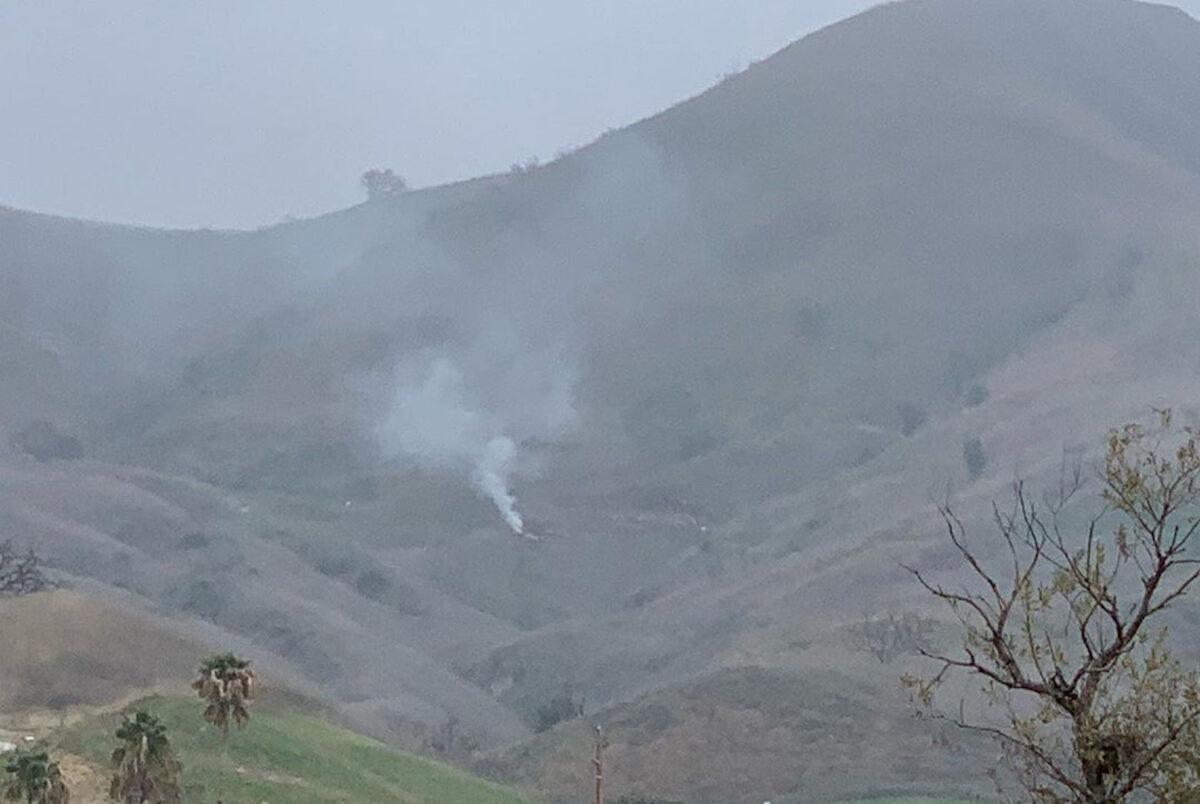 Smoke rises amid foggy weather from the site of a helicopter crash that killed former NBA star Kobe Bryant, his daughter Gianna and seven others, along a hillside in Calabasas, Calif., on Jan. 26, 2020, in this photo obtained via social media. (INSTAGRAM/@PRINCESSOFCALABASAS via Reuters)