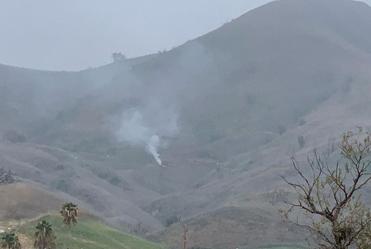 Smoke rises amid foggy weather from the site of a helicopter crash that killed former NBA star Kobe Bryant, his daughter Gianna and seven others, along a hillside in Calabasas, Calif., on Jan. 26, 2020, in this photo obtained via social media. (INSTAGRAM/@PRINCESSOFCALABASAS via Reuters)