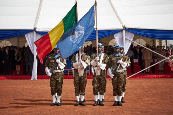 Soldiers hold the UN and Malian flags during the ceremony of Peacekeepers' Day at the operating base of MINUSMA in Bamako, Mali, on May 29, 2018. (Michele Cattani / AFP via Getty Images)