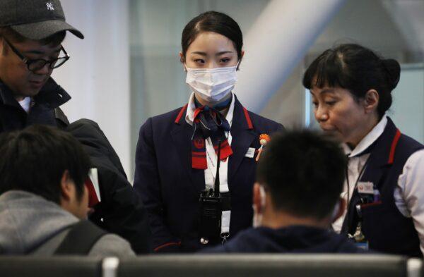 A Japan Airlines worker (C) wears a face mask while working inside a terminal at Los Angeles International Airport (LAX) on Jan. 23, 2020. (Mario Tama/Getty Images)