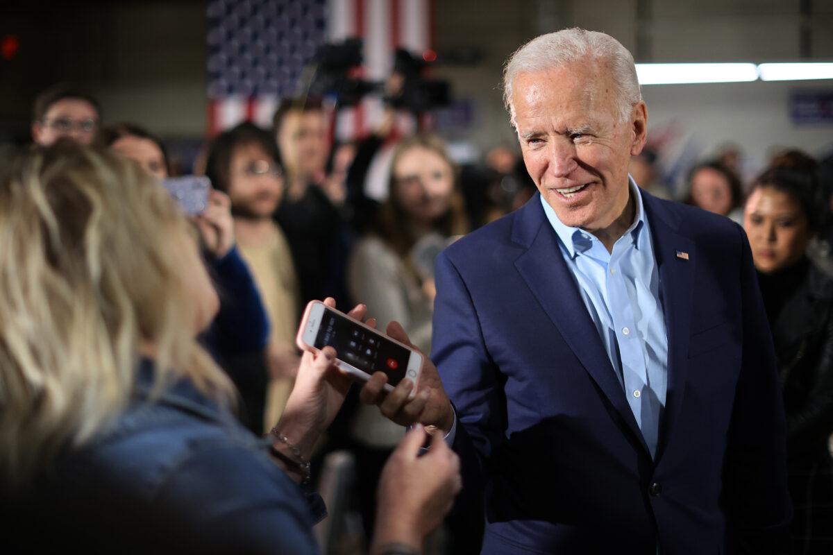 Democratic presidential candidate former Vice President Joe Biden returns a supporter's phone after talking to her relative during a campaign event at the Central Iowa Fairgrounds in Marshalltown, Iowa, on Jan. 26, 2020. (Chip Somodevilla/Getty Images)