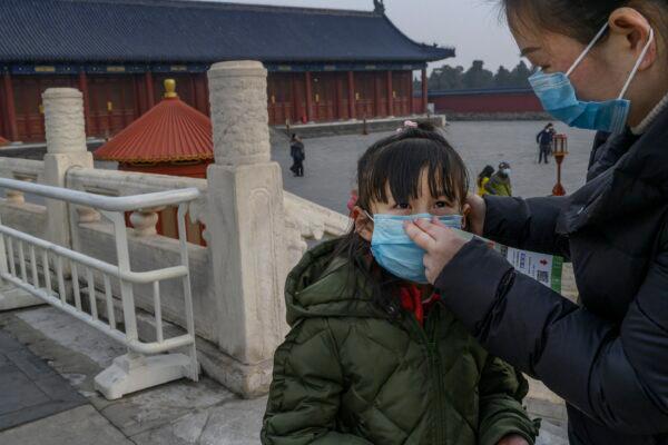 A young Chinese visitor wears a protective mask as she tours the nearly empty grounds of the Temple of Heaven in Beijing, China on Jan. 27, 2020. (Kevin Frayer/Getty Images)