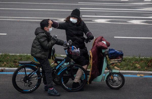 A woman checks her son's forehead in the locked-down city of Wuhan in China on Jan. 27, 2020. (Getty Images)