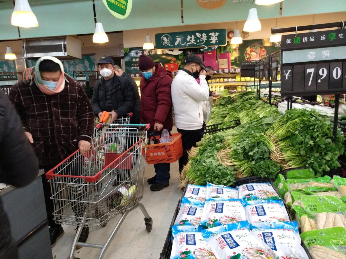 People wearing masks shop at a supermarket on the second day of the Chinese Lunar New Year, following the outbreak of a new coronavirus, in Wuhan, Hubei province, China on Jan. 26, 2020. (cnsphoto via Reuters)