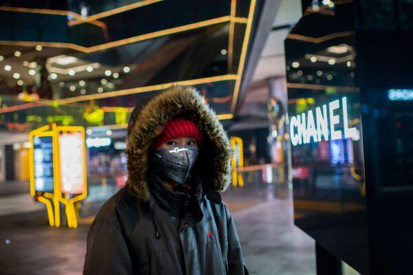 A woman walks at an empty shopping mall in the Sanlitun area in Beijing on Jan. 28, 2020. (Nicolas Asfouri/AFP via Getty Images)