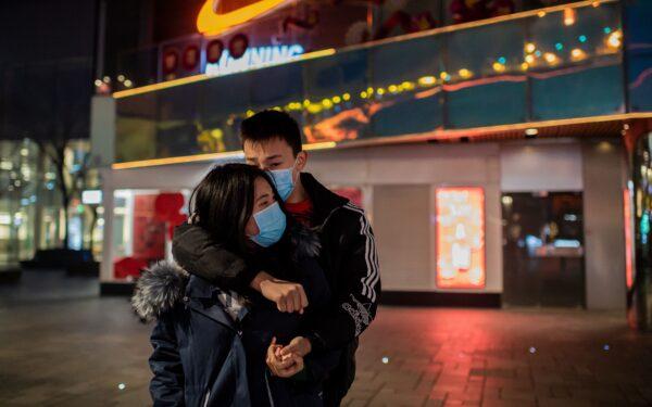 A couple hugs at an empty shopping mall in the Sanlitun area in Beijing on Jan. 28, 2020. (NIcholas Asfouri/AFP via Getty Images)
