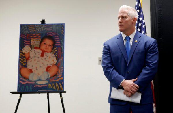 Yolo County District Attorney Jeff Reisig stands next to a photo of Kato Krow Perez, born in 2001, one of five infants believed to be killed by their father, during a news conference in Woodland, Calif., on Jan. 27, 2020. (Rich Pedroncelli/ AP Photo)