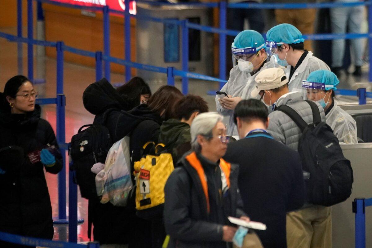 Medical officials are seen as passengers leave the Pudong International Airport in Shanghai, China on Jan. 27, 2020. (Aly Song/Reuters)