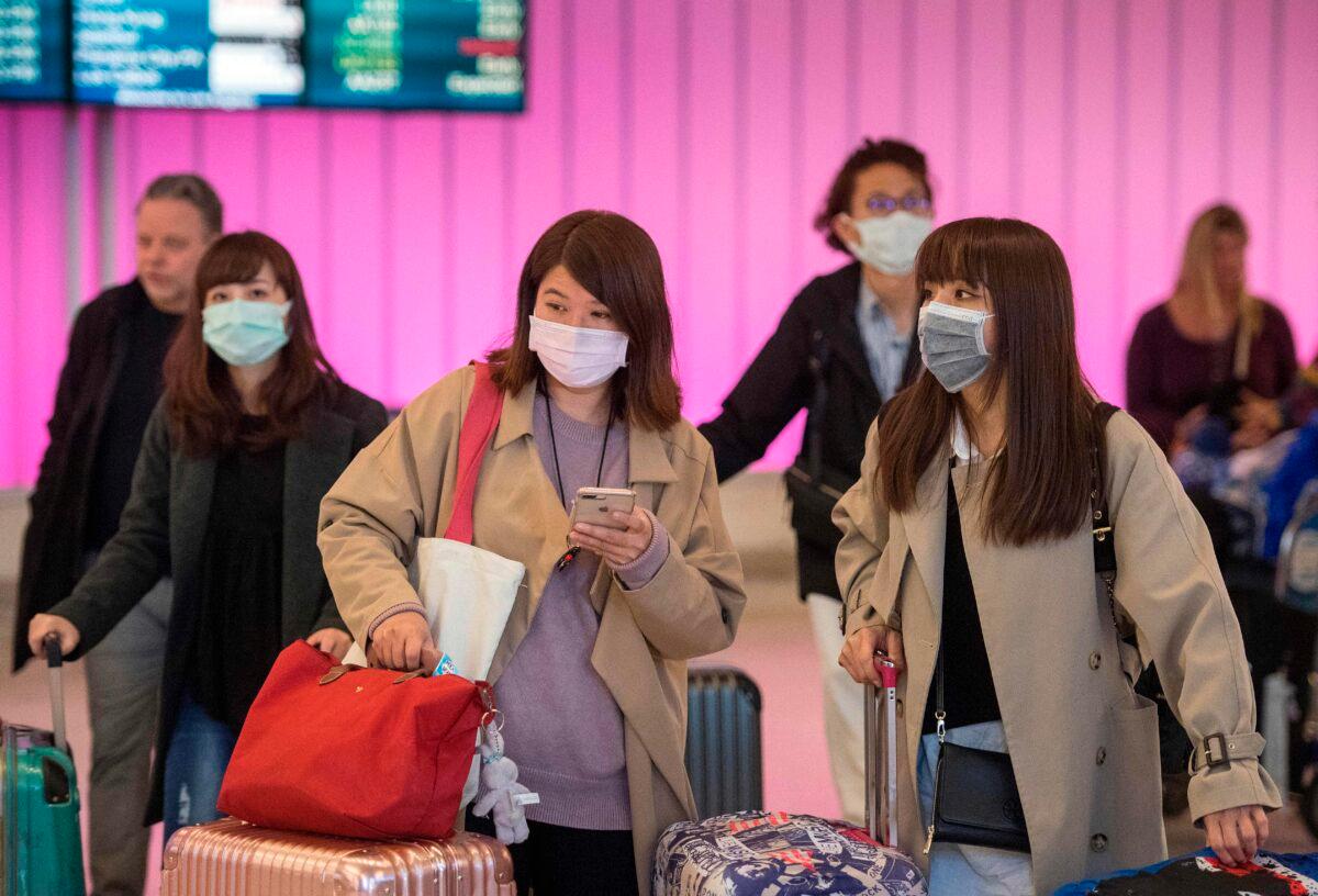 Passengers wear protective masks to protect against the spread of the coronavirus as they arrive at Los Angeles International Airport, Calif., on Jan. 22, 2020. (Mark Ralston/AFP via Getty Images)