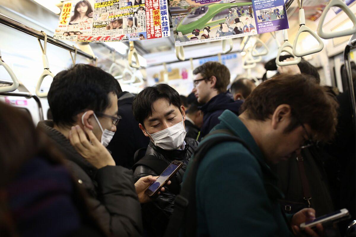 Passengers wearing protective face masks commute on a subway train in Tokyo on Jan. 28, 2020. (Behrouz Mehri/AFP via Getty Images)