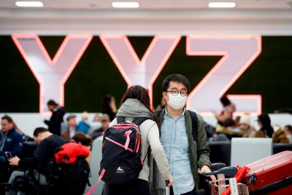 Travellers are seen wearing masks at the international arrivals area at the Toronto Pearson Airport in Toronto, Canada, on Jan. 26, 2020. (Cole Burston/AFP via Getty Images)