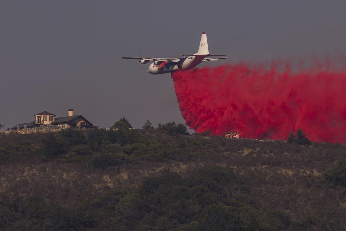 A firefighting Coulson C-130 air tanker drops fire retardant near a house during the Oakmont Fire on Oct. 15, 2017, near Santa Rosa, California. (Illustration - Getty Images | <a href="https://www.gettyimages.com/detail/news-photo/firefighting-coulson-c-130-air-tanker-drops-fire-retardant-news-photo/861820394?adppopup=true">David McNew</a>)