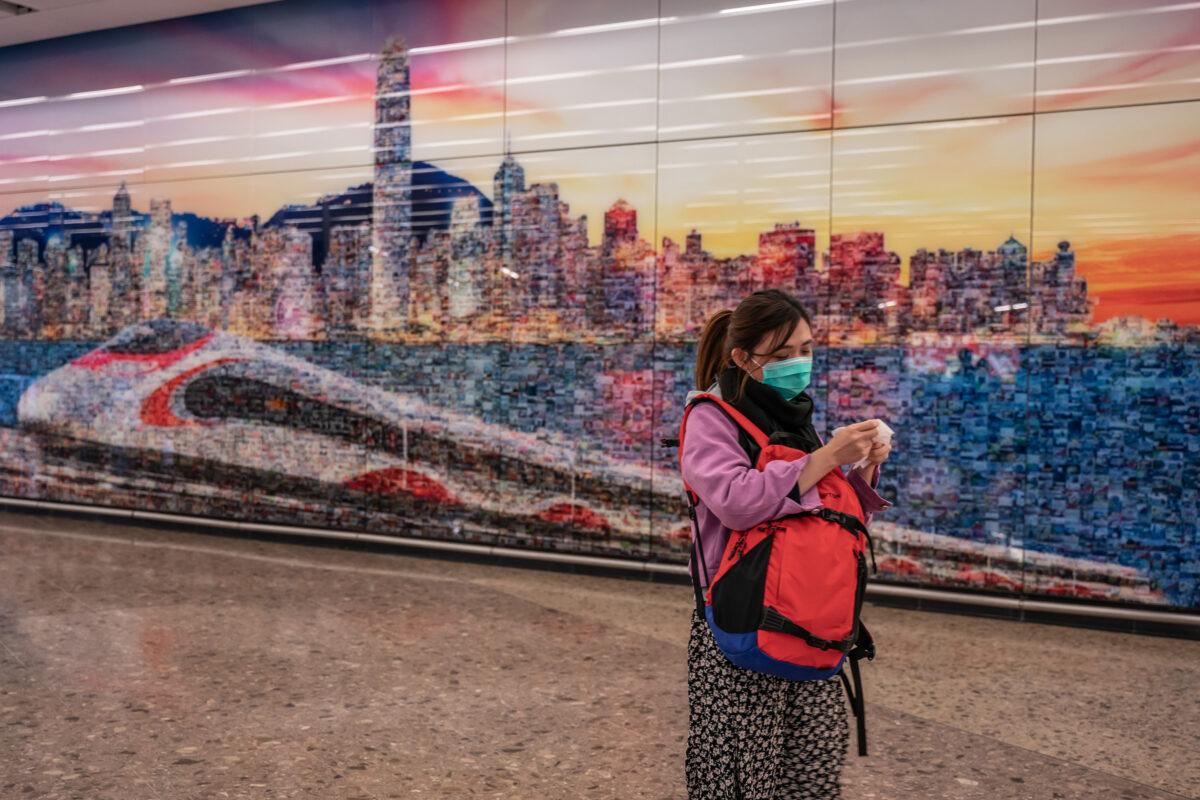 A woman wearing a protective mask exits the arrival hall at Hong Kong High-Speed Rail Station on Jan. 29, 2020. (Anthony Kwan/Getty Images)
