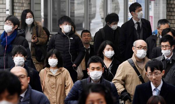 People wearing face masks walk on a street in Nara, western Japan, on Jan. 29, 2020. (Nobuki Ito/Kyodo News via AP)