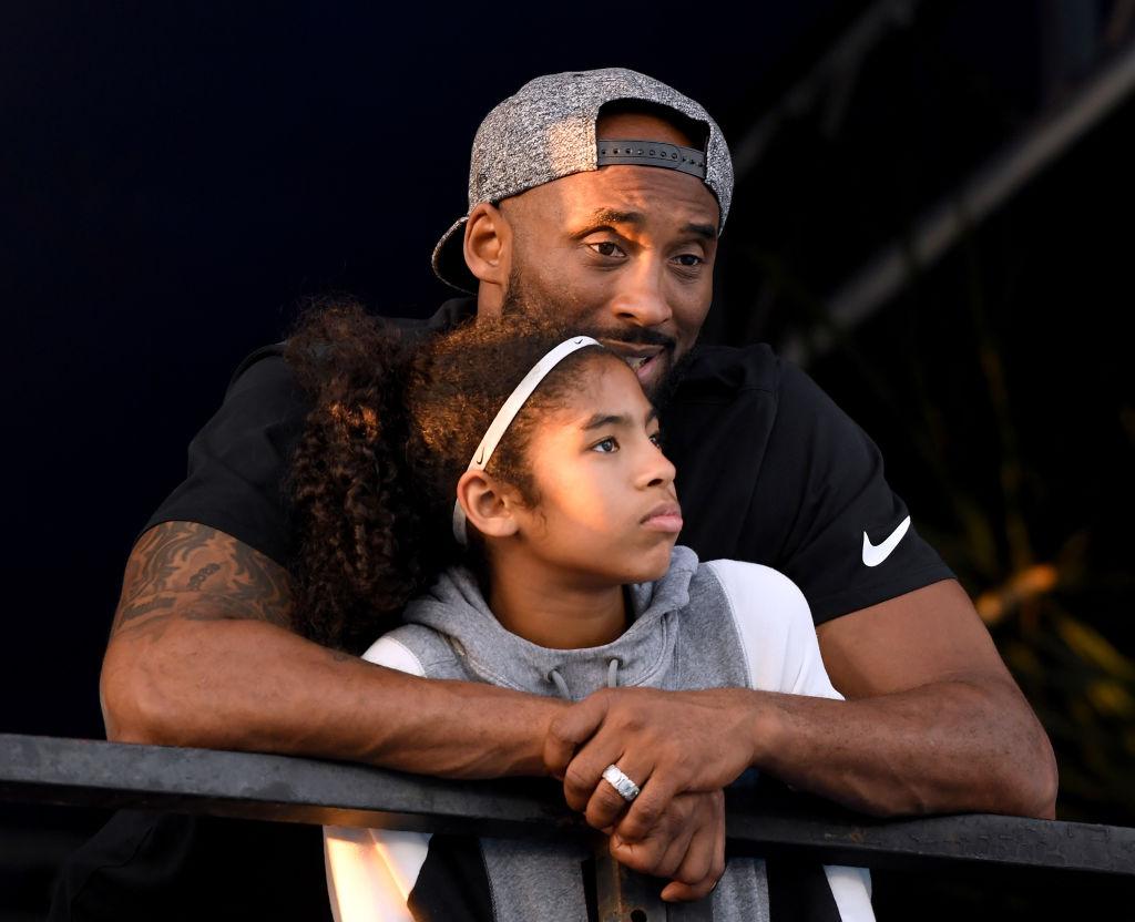 Kobe and Gianna look on during Day 2 of the Phillips 66 National Swimming Championships at the Woollett Aquatics Center in Irvine, California, on July 26, 2018. (©Getty Images | <a href="https://www.gettyimages.com/detail/news-photo/kobe-bryant-and-daughter-gianna-bryant-watch-during-day-2-news-photo/1005861746?adppopup=true">Harry How</a>)