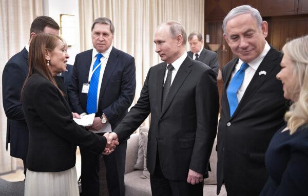 Russian President Vladimir Putin shakes hands with Yaffa Issachar, the mother of US-Israeli Naama Issachar who was jailed in Moscow on drug charges, during a meeting in Jerusalem, Israel, on Jan. 23, 2020. (Alexey Nikolsky/Sputnik/AFP via Getty Images)