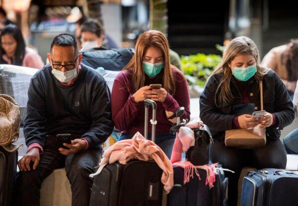 Passengers wear face masks to protect against the spread of the Coronavirus as they arrive on a flight from Asia at Los Angeles International Airport, Calif., on Jan. 29, 2020. (Mark Ralston/AFP via Getty Images)