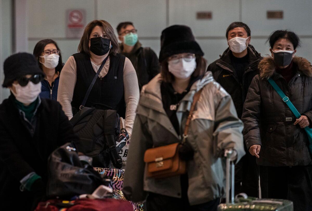Passengers wear protective masks as they arrive at Beijing Capital Airport in Beijing, China, on Jan. 30, 2020. (Kevin Frayer/Getty Images)
