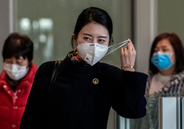A Chinese stewardess adjusts her mask after disembarking from a flight at Beijing Capital Airport in Beijing, China, on Jan 30, 2020. (Kevin Frayer/Getty Images)