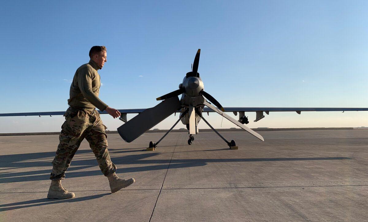 A member of the U.S. forces walks past a drone in the Ain al-Asad airbase in the western Iraqi province of Anbar, Iraq, on Jan. 13, 2020. (Ayman Henna/AFP via Getty Images)