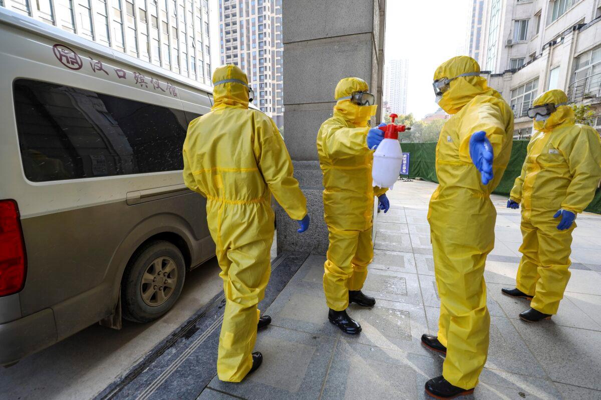 Funeral workers disinfect themselves after handling a virus victim in Wuhan in central China's Hubei Province on Jan. 30, 2020. (Chinatopix via AP)