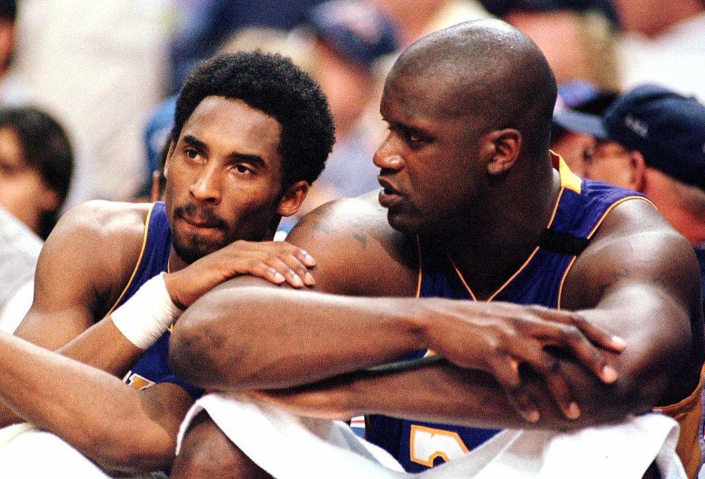 Bryant speaks with teammate O'Neal while playing the Phoenix Suns in the Western Conference semi-finals at America West Arena in Phoenix on May 14, 2000. (©Getty Images | <a href="https://www.gettyimages.com/detail/news-photo/los-angeles-lakers-forward-kobe-bryant-speaks-with-teammate-news-photo/51965495?adppopup=true">MIKE FIALA</a>)