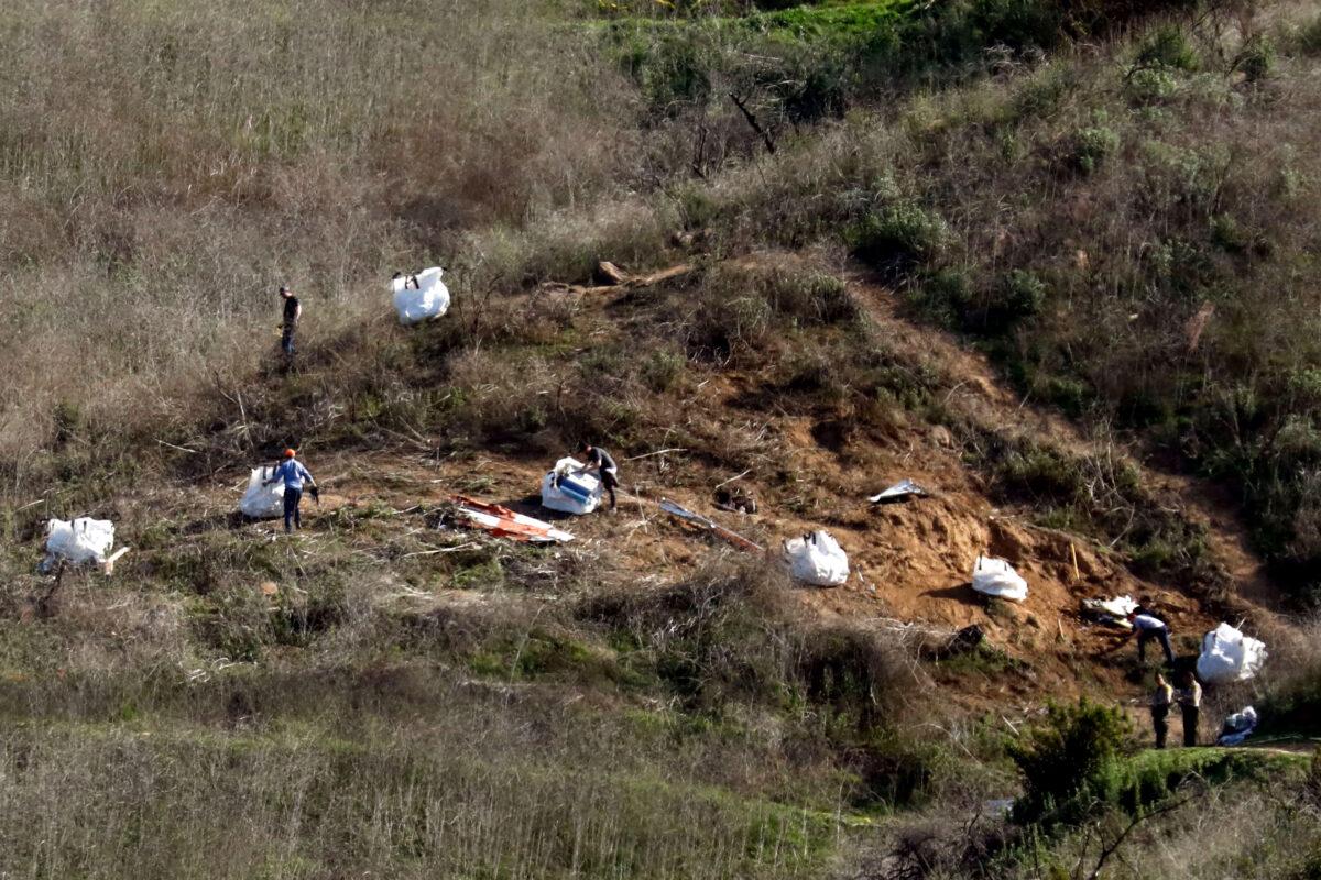 Personnel collect debris while working with investigators at the helicopter crash site of NBA star Kobe Bryant in Calabasas, Californi,a on Jan. 28, 2020. (Patrick T. Fallon/Reuters)