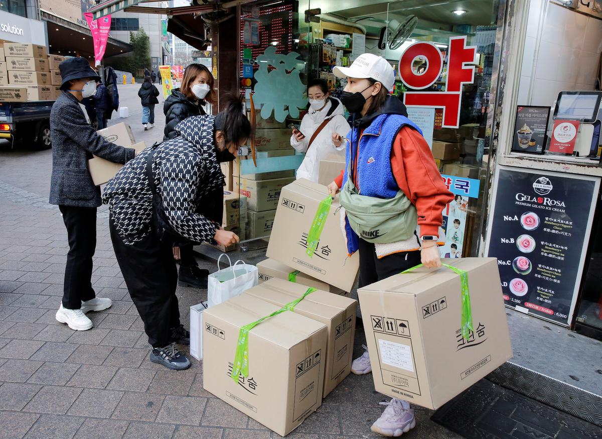 Tourists leave after buying masks to prevent contracting coronavirus, at a pharmacy in the Myeong-dong in Seoul, South Korea on Jan. 31, 2020. (Heo Ran/Reuters)