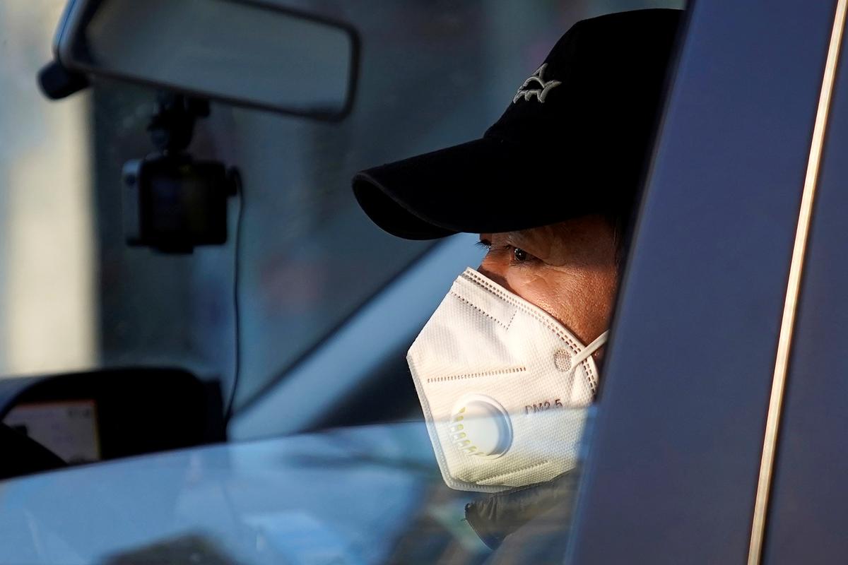 A driver wears a mask as he drives in Shanghai, China on Jan. 31, 2020. (Aly Song/Reuters)