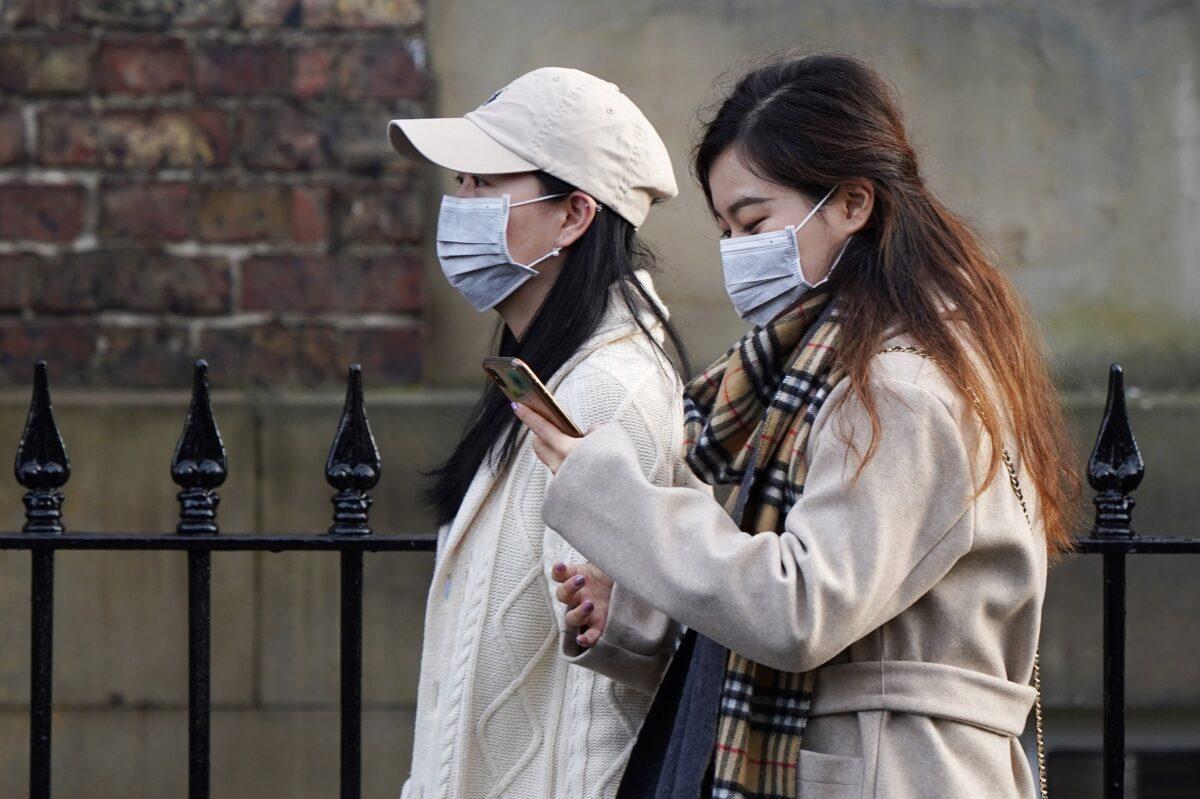 Two women wearing face masks walk through the city center near to the Royal Victoria Infirmary where two patients who have tested positive for the Wuhan coronavirus are being treated by specialist medical workers in Newcastle, England, on Jan. 31, 2020. (Ian Forsyth/Getty Images)