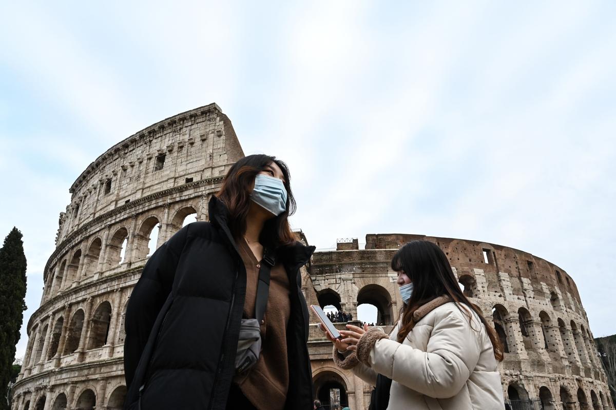 Tourists wearing protective respiratory masks tour outside the Colosseo monument in downtown Rome, Italy, on Jan. 31, 2020. (Alberto Pizzoli/AFP via Getty Images)