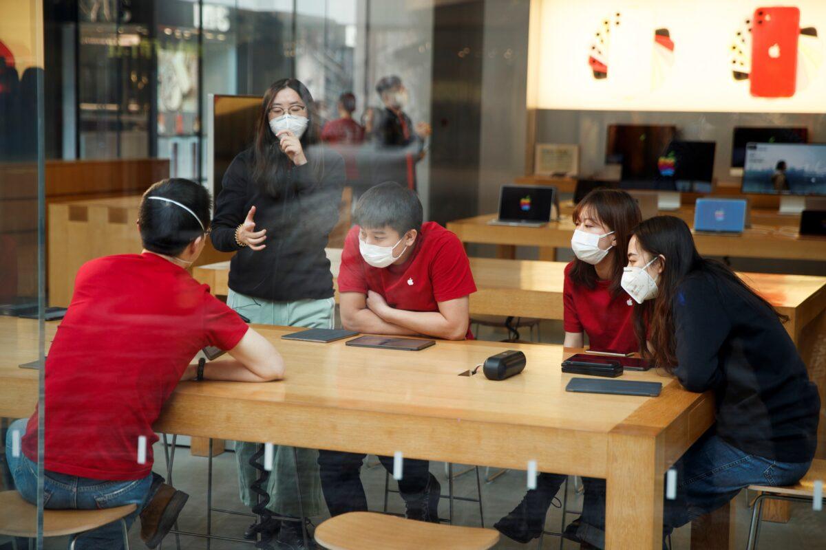 People wear face masks as they listen to a presentation in an Apple Store in the Sanlitun shopping district in Beijing as China is hit by an outbreak of the new coronavirus, on Jan. 25, 2020. (Thomas Peter/Reuters)