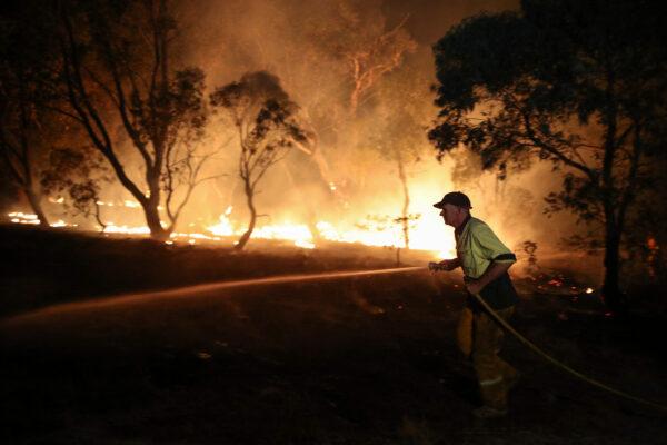 A firefighter from a local brigade works to extinguish flames after a bushfire burnt through the area in Bredbo, New South Wales, Australia, on Feb. 2, 2020. (Loren Elliott/Reuters)