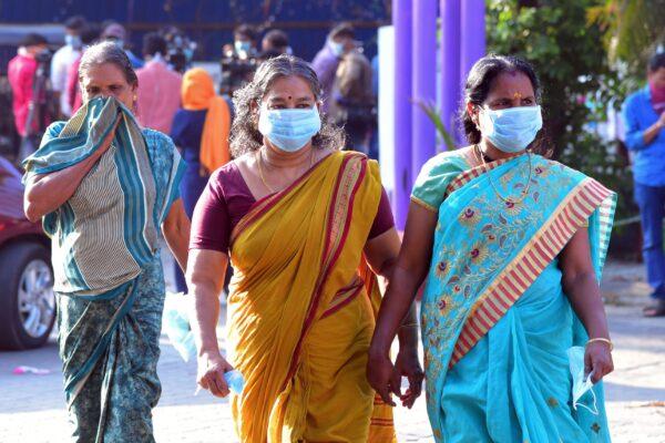 Residents and hospital visitors wearing facemaks walk outside the Government Medical College in Thrissur where the first confirmed case of the SARS-like virus in India is kept in isolation on Jan. 30, 2020. (AFP via Getty Images)